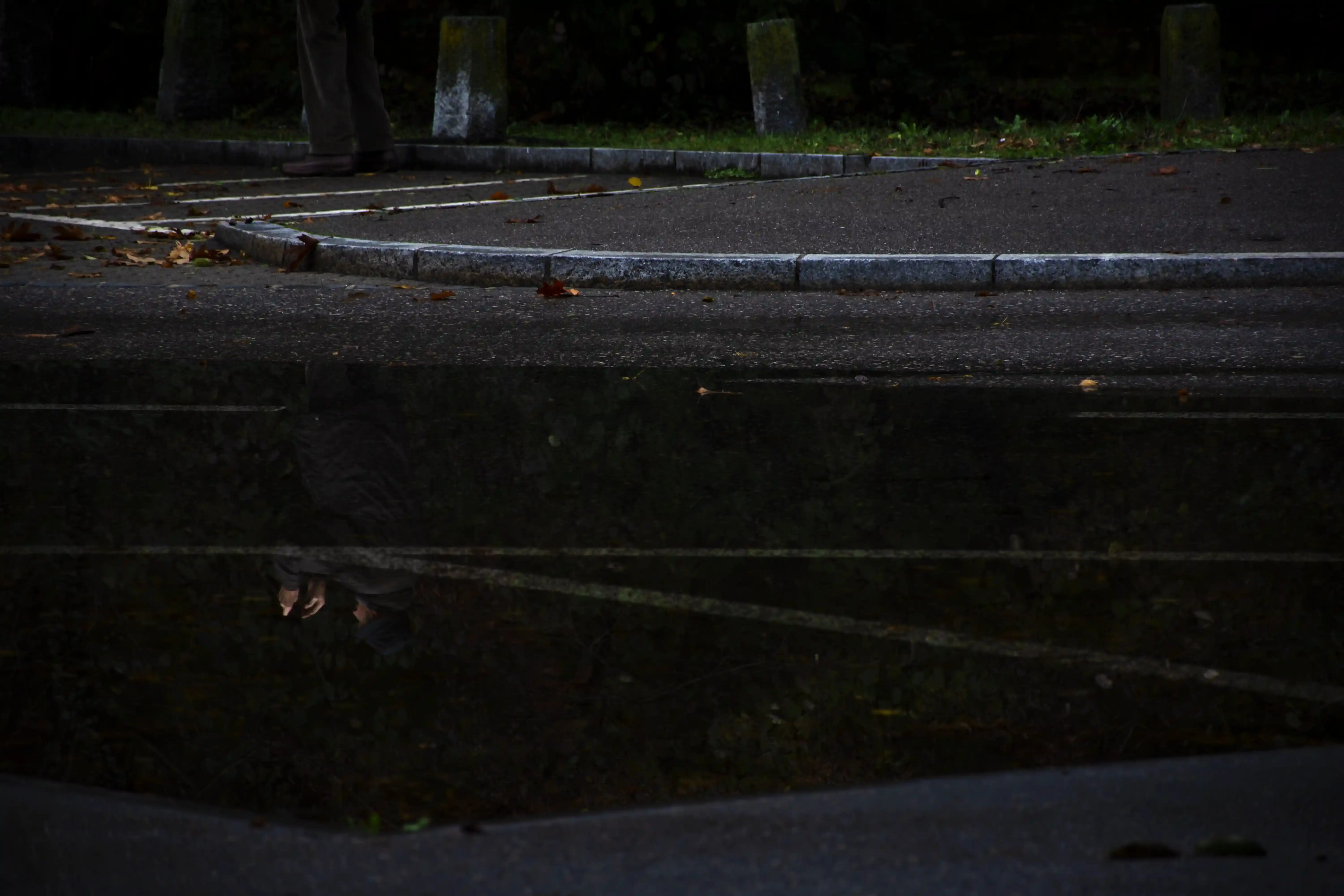Dettaglio ravvicinato dell'acqua che ricopre la pavimentazione urbana di Locarno; un'esplorazione visiva sui riflessi e sui nuovi confini durante l'allagamento